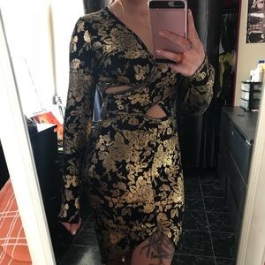 Long sleeve black and gold fitted dress.